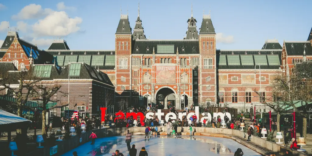 Shot of the Rijksmuseum and I Amsterdam sign with people ice skating 