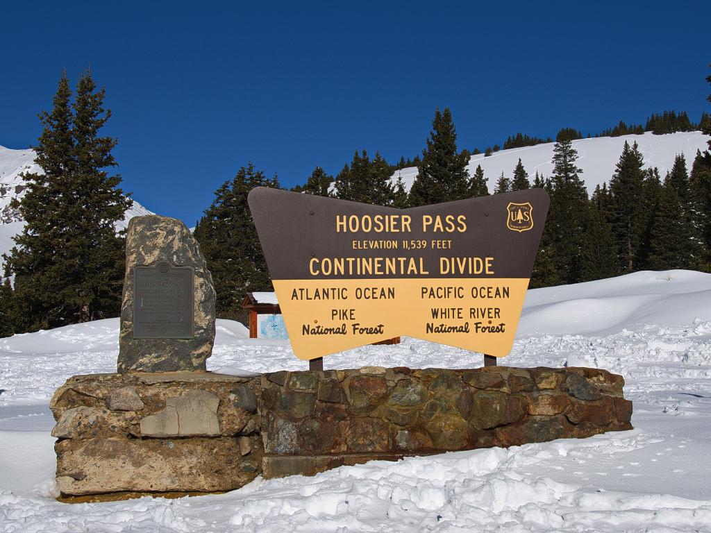 Department of Agriculture Forest Service sign marking the Continental Divide at Hoosier Pass near Breckenridge Colorado with snow around