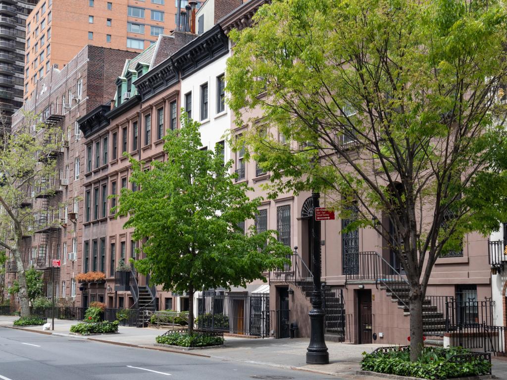 Row of beautiful old and fancy townhouses along an empty street on the Upper East Side of New York City