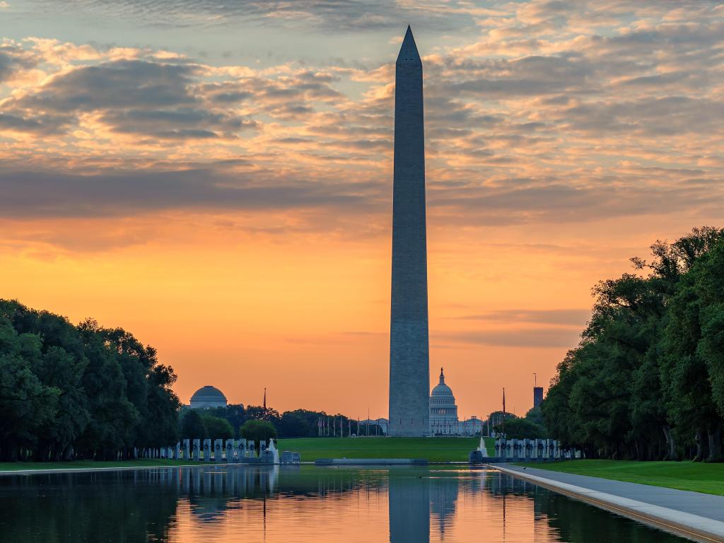 Washington Monument at sunrise in Washington DC, USA. The White House can be seen in the background.