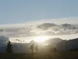 Joel and Ellie from the HBO TV series "The Last of Us" walking during a sunset through the mountains
