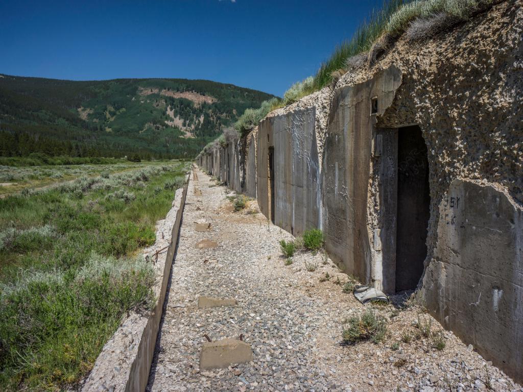 Crumbling grey walls of disused concrete WW2 training bunkers at Camp Hale Memorial Campground, Colorado