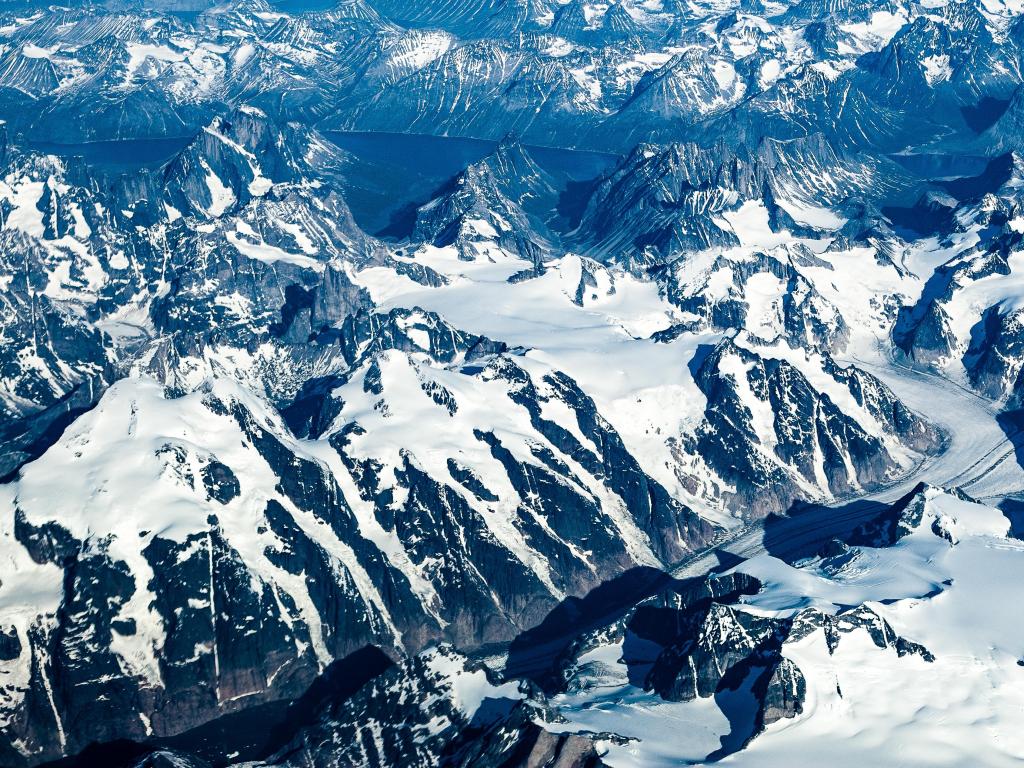 Greenland's terrain comprising of mountains, snow and fjords.