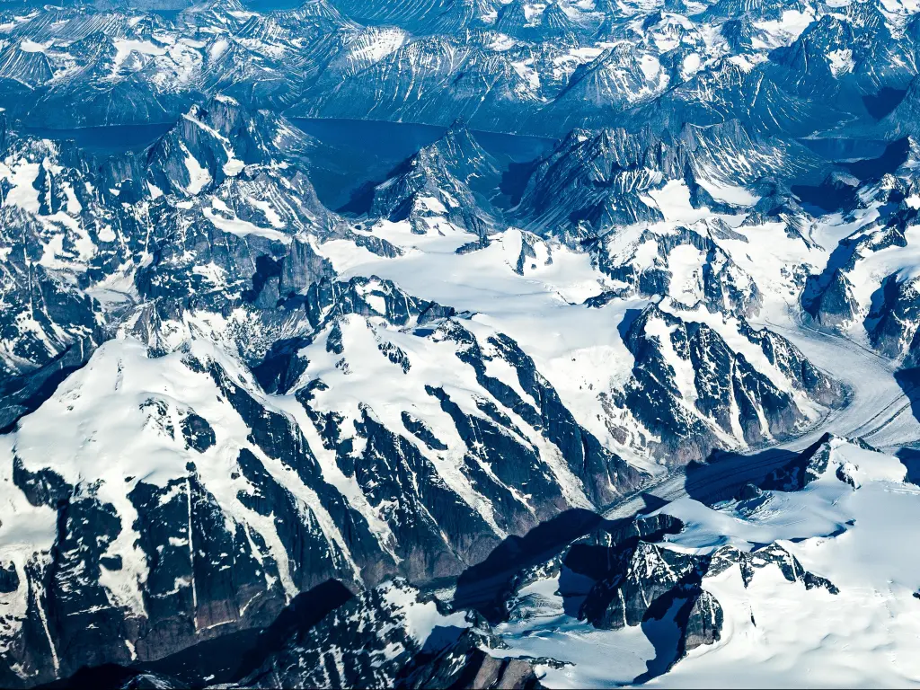Greenland's terrain comprising of mountains, snow and fjords.