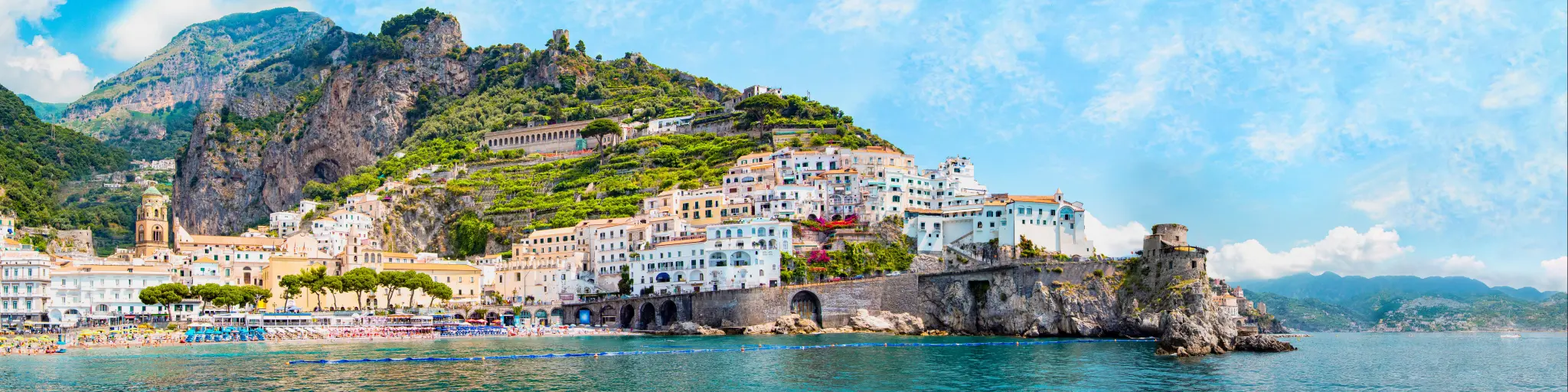 Panoramic view, aerial skyline of small haven of Amalfi village with tiny beach and colorful houses located on rock. 