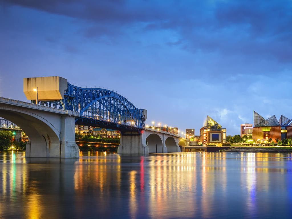 Chattanooga, Tennessee, USA with the downtown skyline taken at night and the bridge over the river in the foreground.