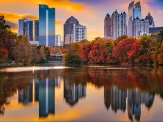 Atlanta, Georgia, USA with water in the foreground and Piedmont Park and the city skyline in the background reflecting in the water at autumn.
