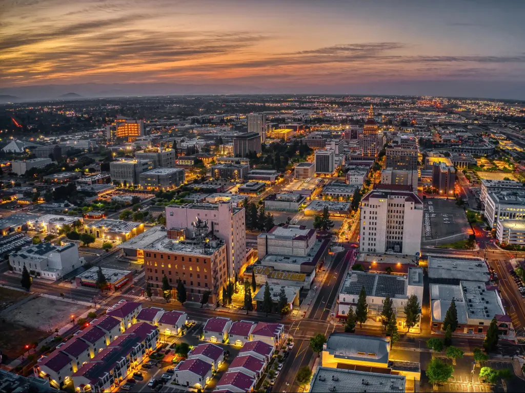 Fresno, California, USA with an aerial view of the city at dusk.