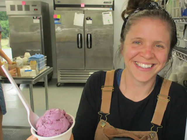 Kristina Zontini, founder at Super Secret Ice Cream, in the kitchen holding a pot of berry-flavored ice cream