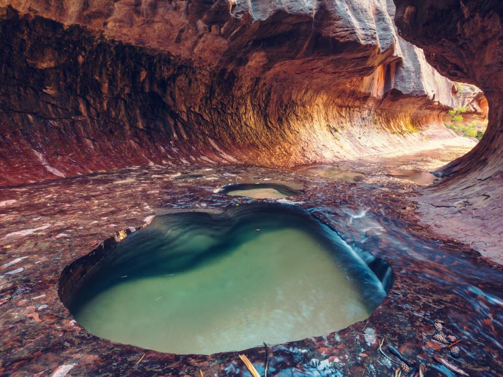 Zion National Park, Utah, USA taken at the Narrows underground with clear water pool in the foreground.