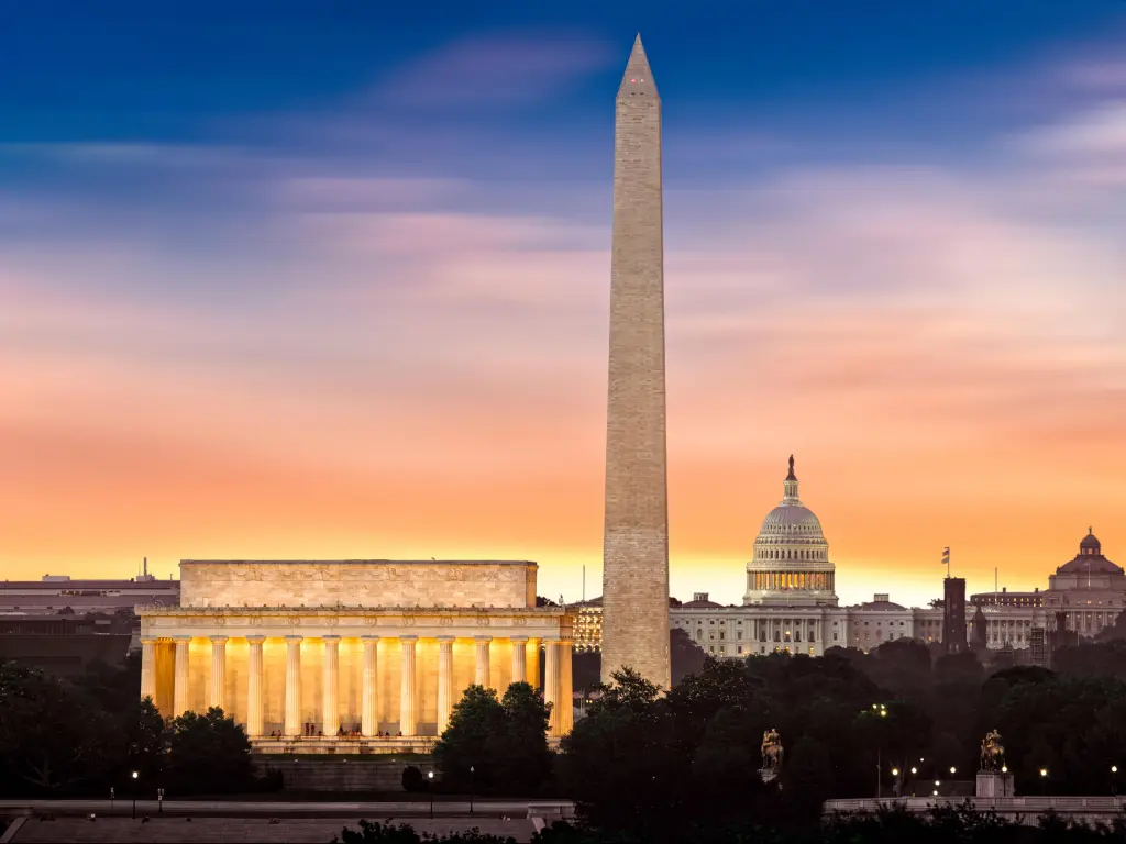 Washington, DC, USA taken at dawn over Washington with three iconic monuments illuminated at sunrise: Lincoln Memorial, Washington Monument and the Capitol Building.