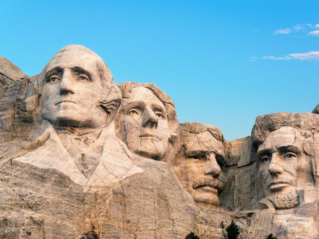 Mount Rushmore, USA taken closely to the faces stoned in the mountain side on a sunny day with a blue sky above.