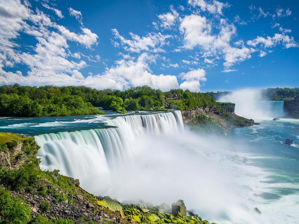 Niagara Falls, New York, USA with the waterfall in the foreground on a sunny day.