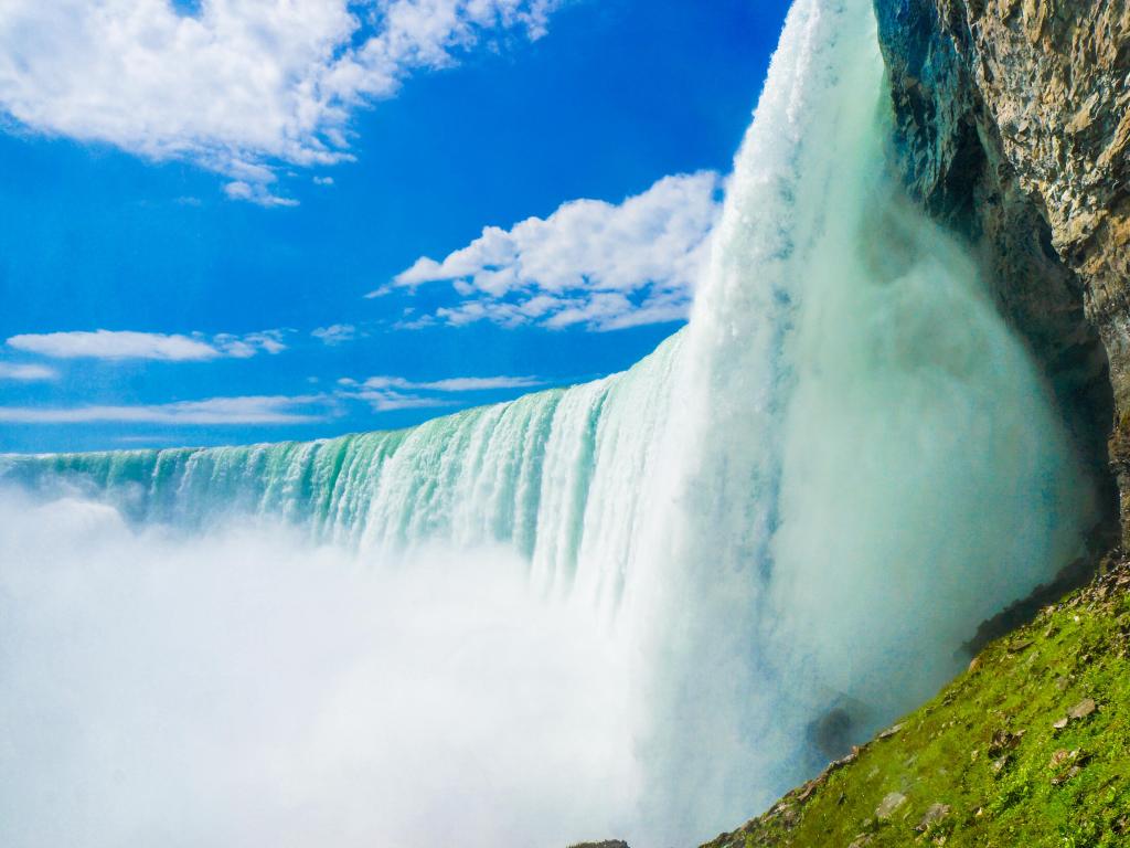 Niagara Falls, USA/Canada with the amazing falls up close, taken on a sunny day with a few clouds and water spray rising in the air.