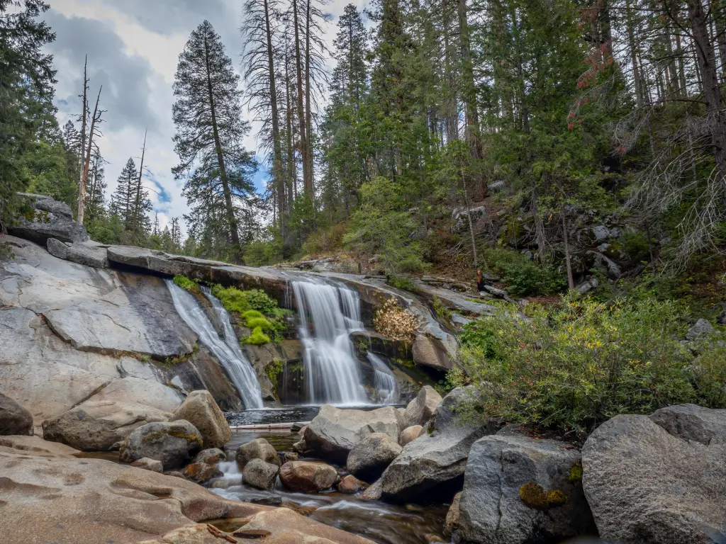 Beautiful cascading water in the forested section of Yosemite National Park on a cloudy day