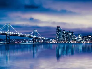 San Francisco, California, USA with a night view of beautiful San Francisco city skyline with lit buildings, bay and bridge.