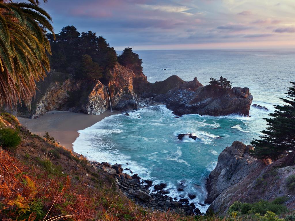 McWay Falls, Pfeiffer Big Sur State Park, California, USA taken at sunset with a cove surrounded by caves and a beautiful sea.