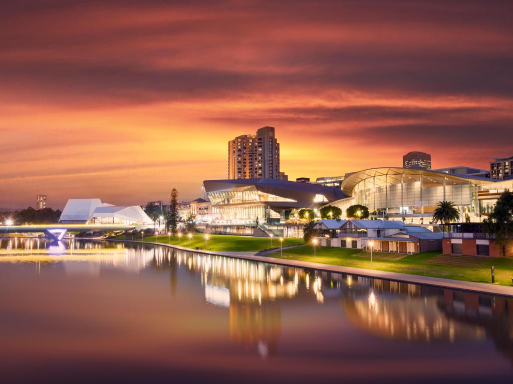 Riverside buildings reflected in the water at night