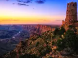 Grand Canyon, Grand Canyon National Park, Arizona with the Watchtower in the foreground at sunset overlooking the great valley, rocks and river below.