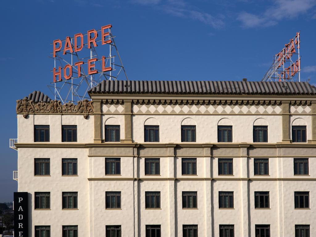 Facade and red sign of the hotel, on a sunny day