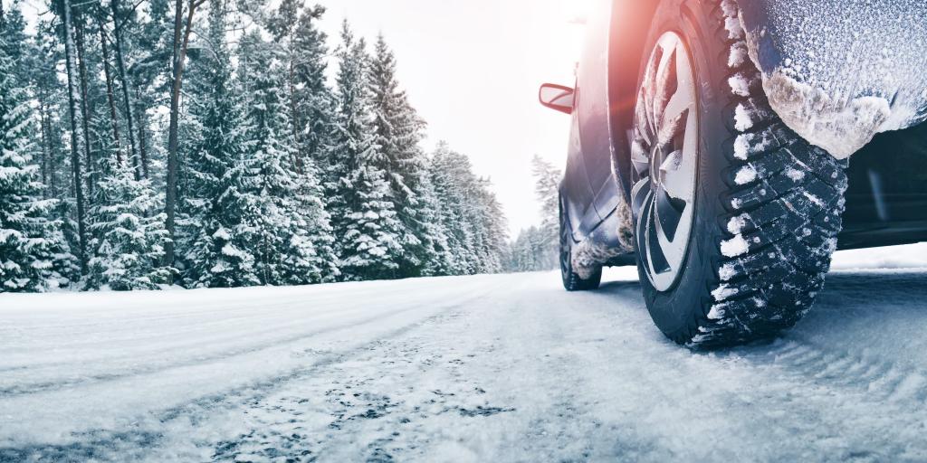 A close up of a car's tyres on a snowy road