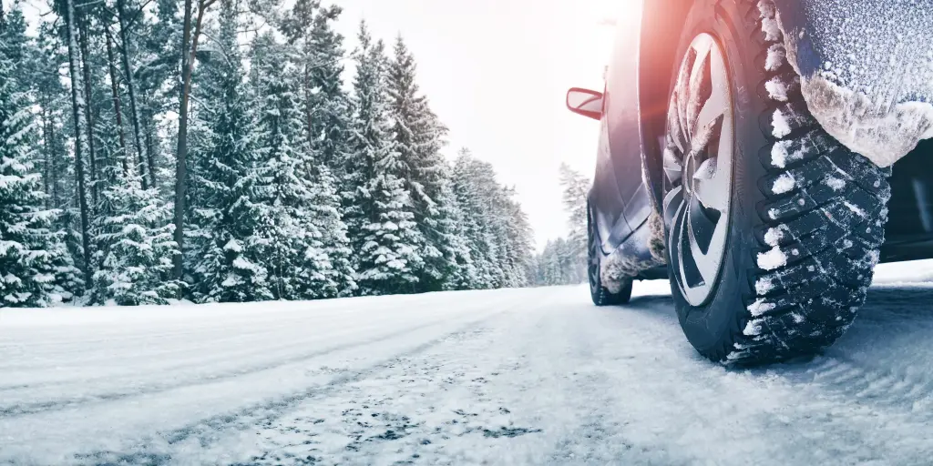 A close up of a car's tyres on a snowy road