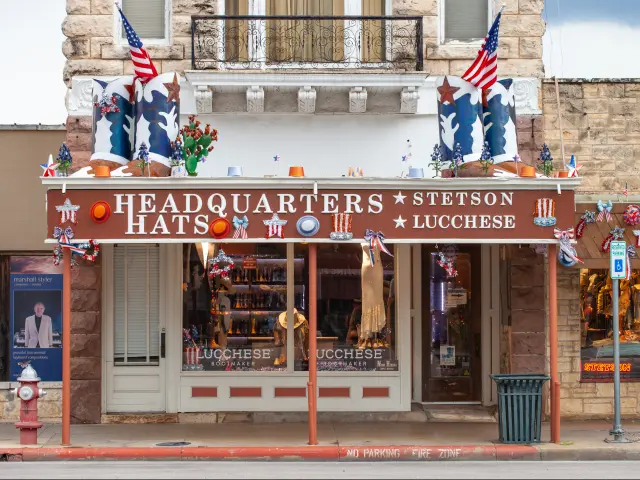 Headquarters Hats storefront selling Stetson hats and Lucchese boots in the old Fredericksburg bank building.