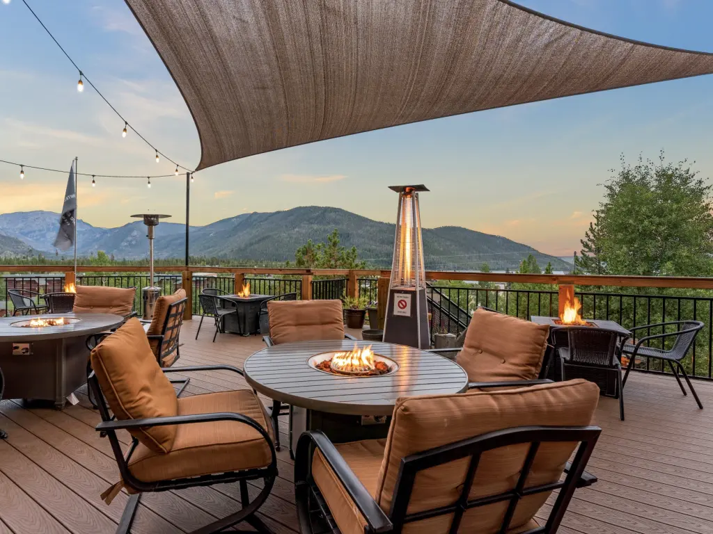 Outdoor sitting area on a terrace overlooking the mountains with firepits on the tabkes