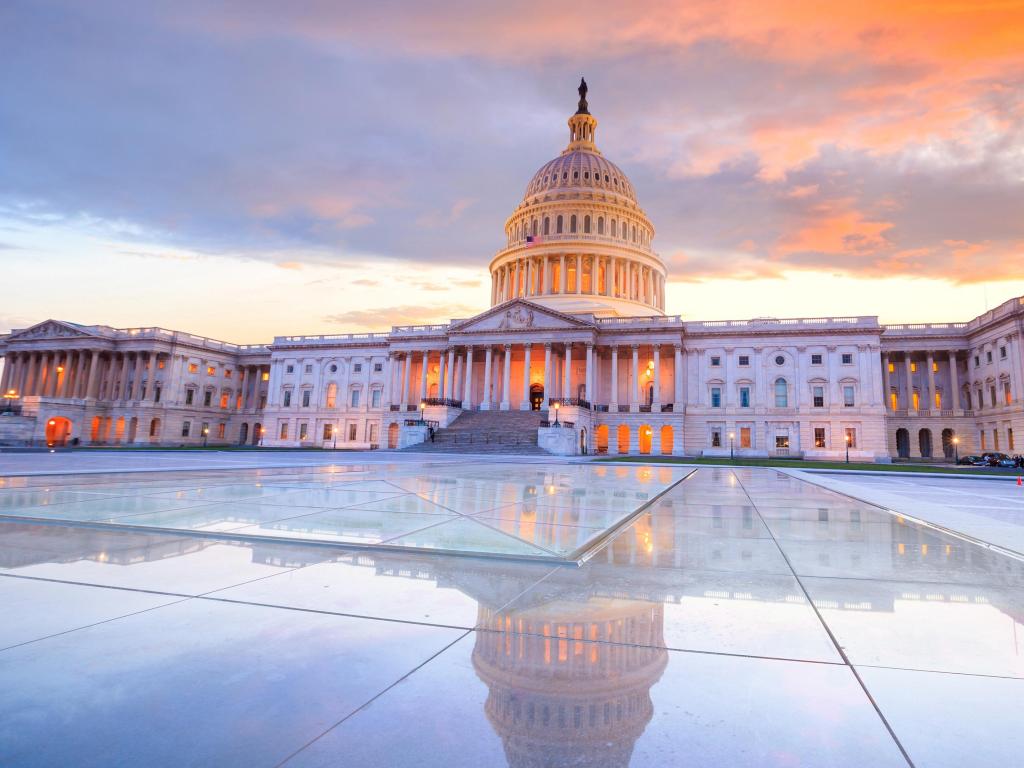United States Capitol, Washington DC, USA with the dome lit up at night and reflected on the ground and taken at sunset. 