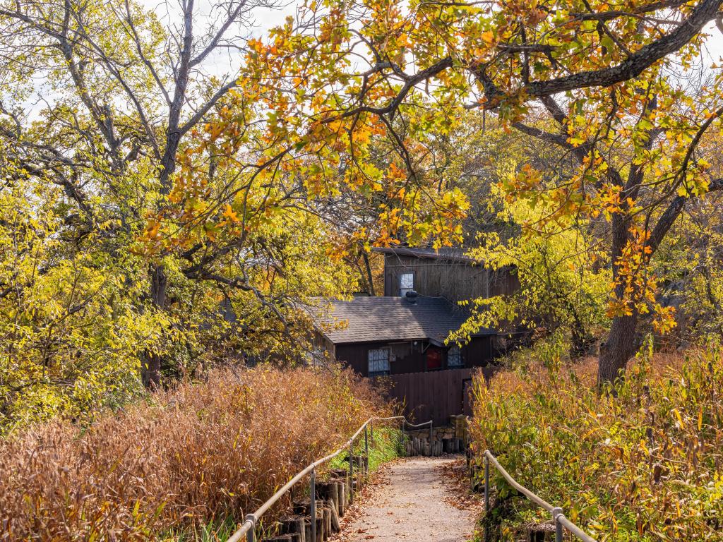 Beautiful landscape of Lake Murray State Park at Oklahoma during fall with trees surrounding a wooden building.