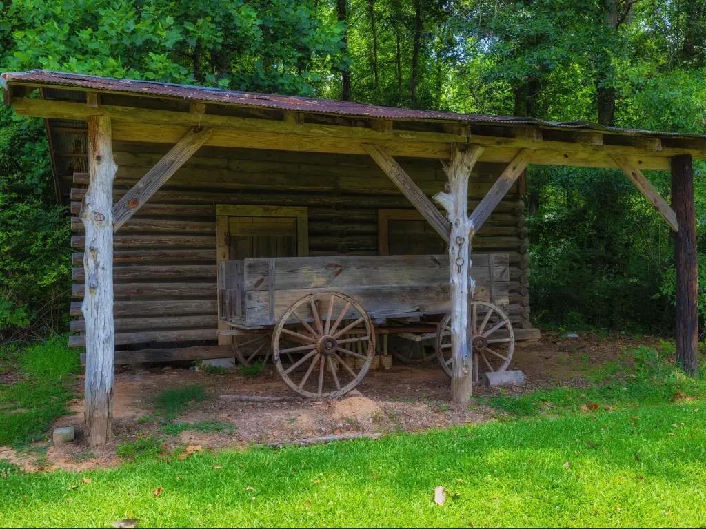 Historic outbuildings at French Camp, Mississippi, with a wooden wagon out front