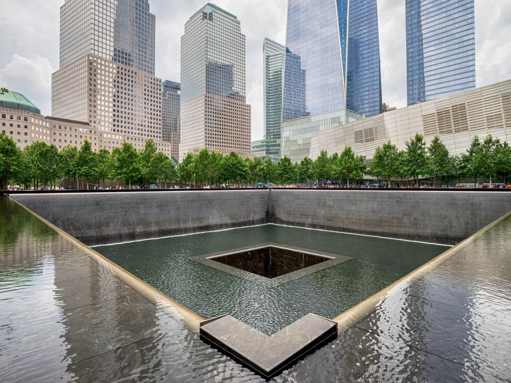 The somber memorial pool at the site of the Twin Towers tragedy, surrounded by skyscrapers