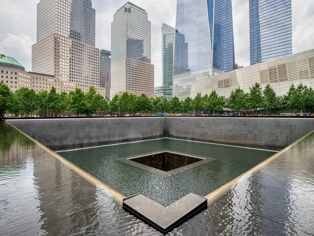 The somber memorial pool at the site of the Twin Towers tragedy, surrounded by skyscrapers