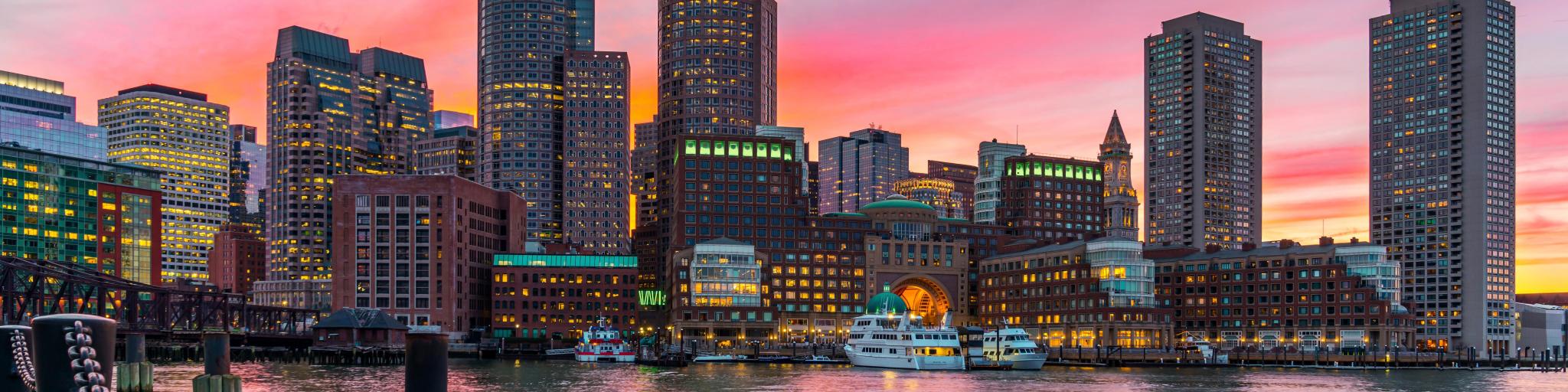 Boston, Massachusetts, USA with the city skyline and Fort Point Channel at sunset as viewed from Fan Pier Park.