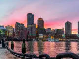 Boston, Massachusetts, USA with the city skyline and Fort Point Channel at sunset as viewed from Fan Pier Park.