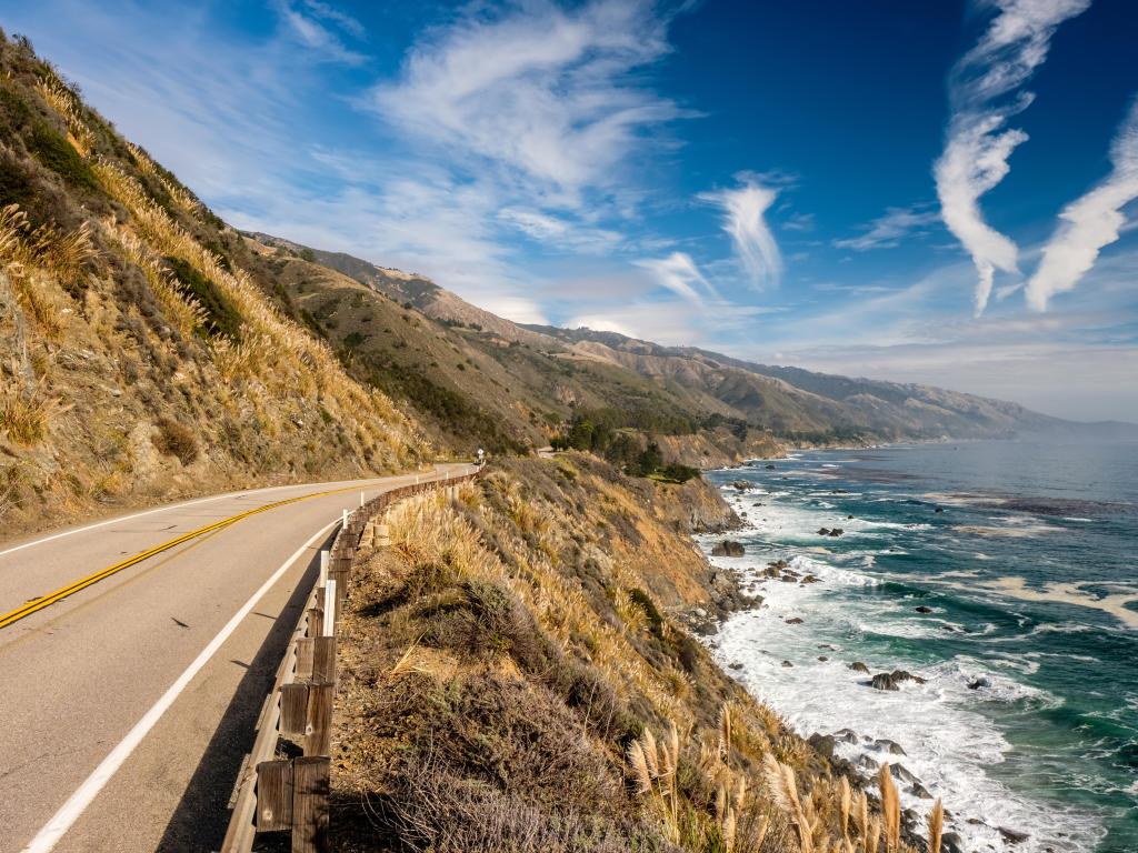 A stretch of Highway 1 by the Pacific coast, California, with waves crashing at the side of the road