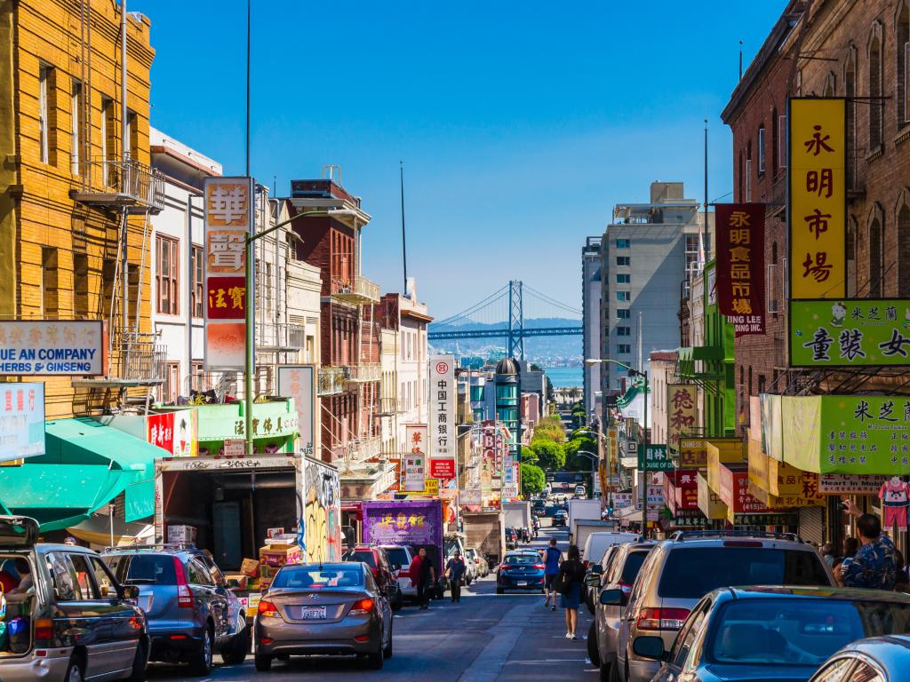 A street in Chinatown in San Francisco with the Oakland Bay Bridge in the background