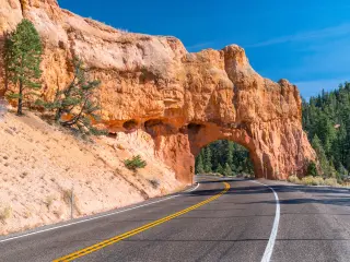 Arch tunnel through rock near Red Canyon on a sunny day