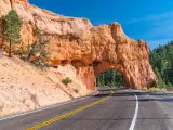 Arch tunnel through rock near Red Canyon on a sunny day