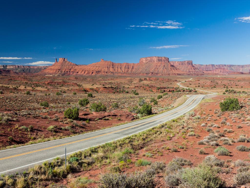 Castle Valley, Moab, Utah, USA taken on a clear sunny day with a road leading to the formation in the distance.
