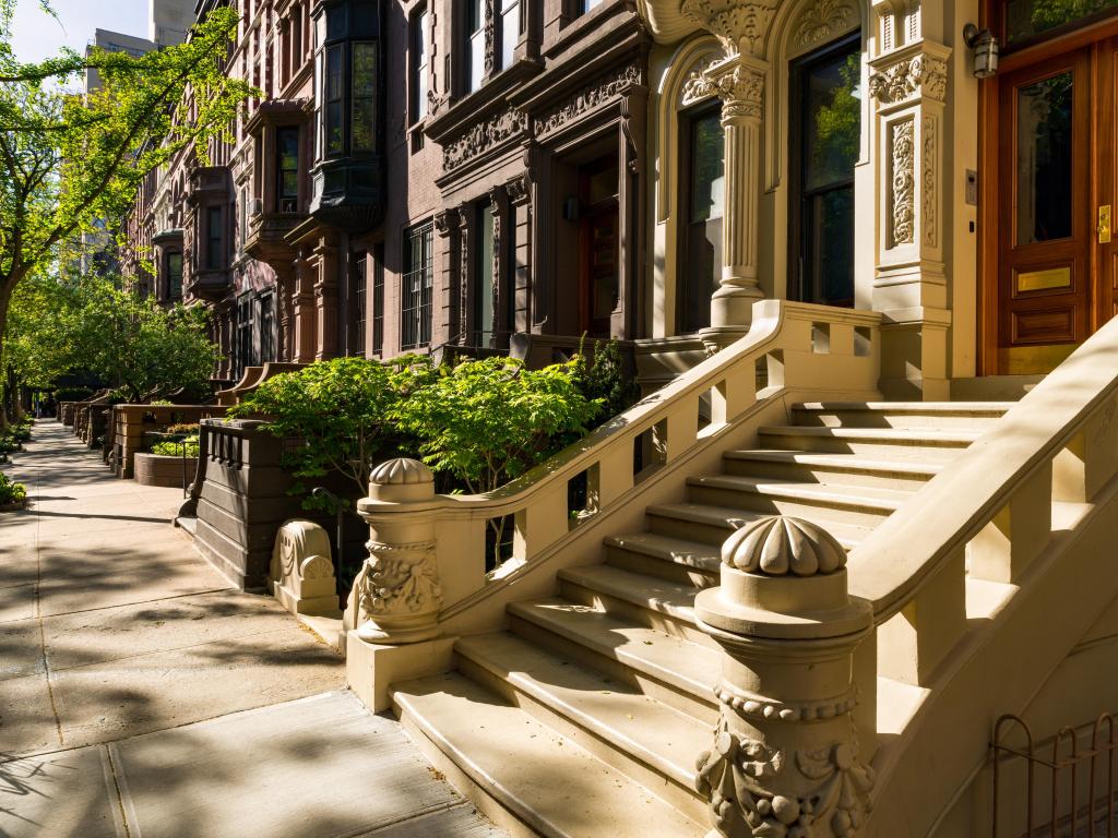 Beautiful brownstone houses, their intricate entrances and stairs on a sunny morning
