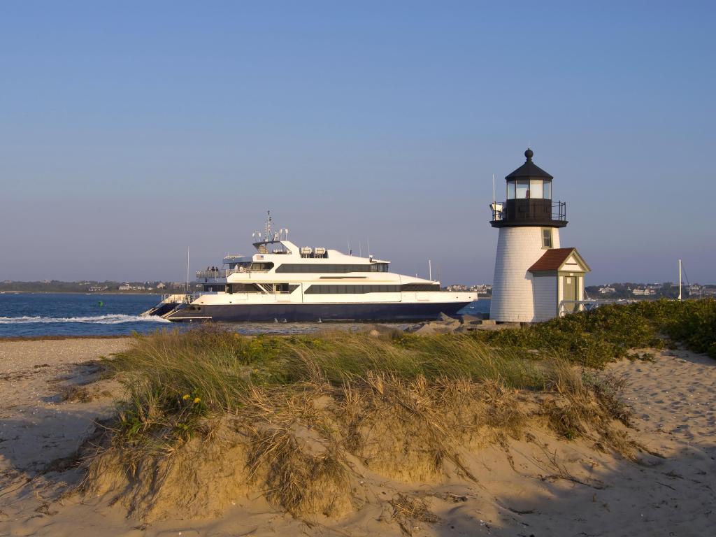 Ferry passing by Brant Point lighthouse on a sunny day