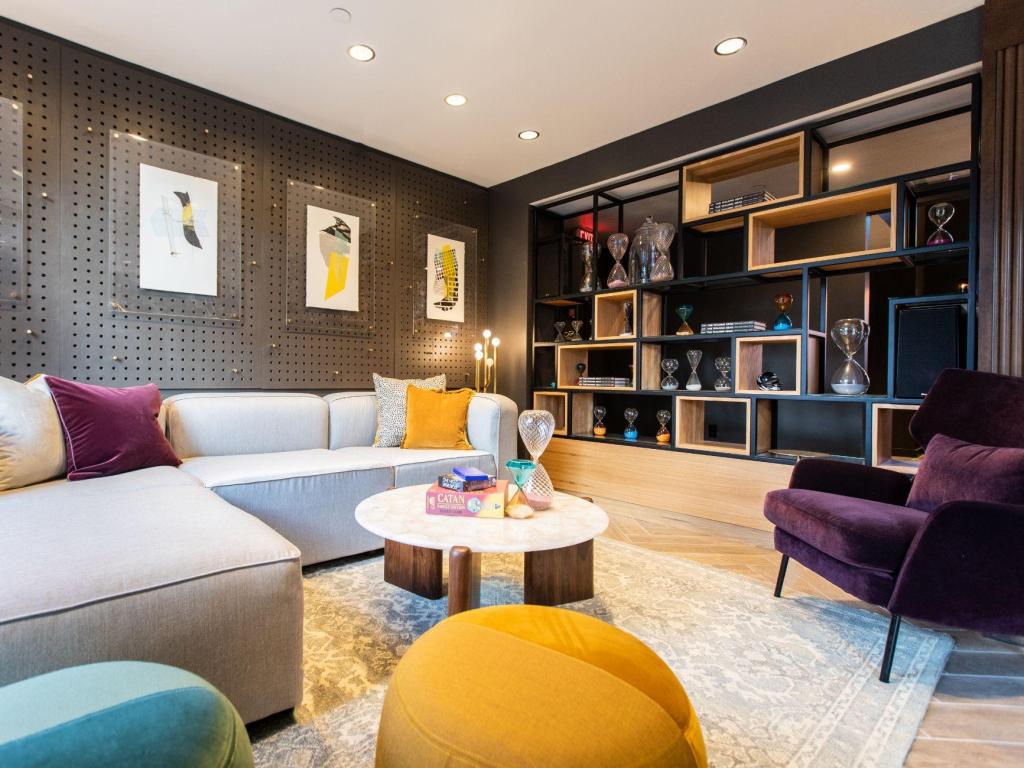 Bright, contemporary lobby setting at The Darwin Hotel, with comfy yellow and purple sofas, board games, and modern artwork