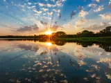 Sunset over water near Omaha, Nebraska with rays of light shimmering on the clouds and water