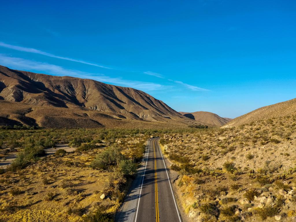 Anza-Borrego State Park mountains with road going through the centre and blue skies in the distance.