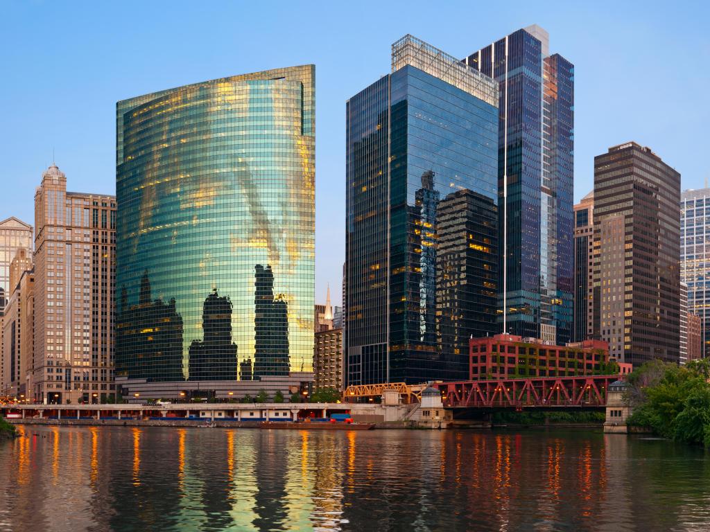 Chicago Downtown, Illinois, USA taken in summer at sunset with the downtown district in the background reflecting in the water in the foreground and taken against a clear blue sky.