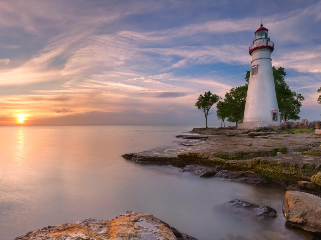 Lake Erie in Ohio, USA with the Marblehead Lighthouse on the edge of the lake at sunrise.