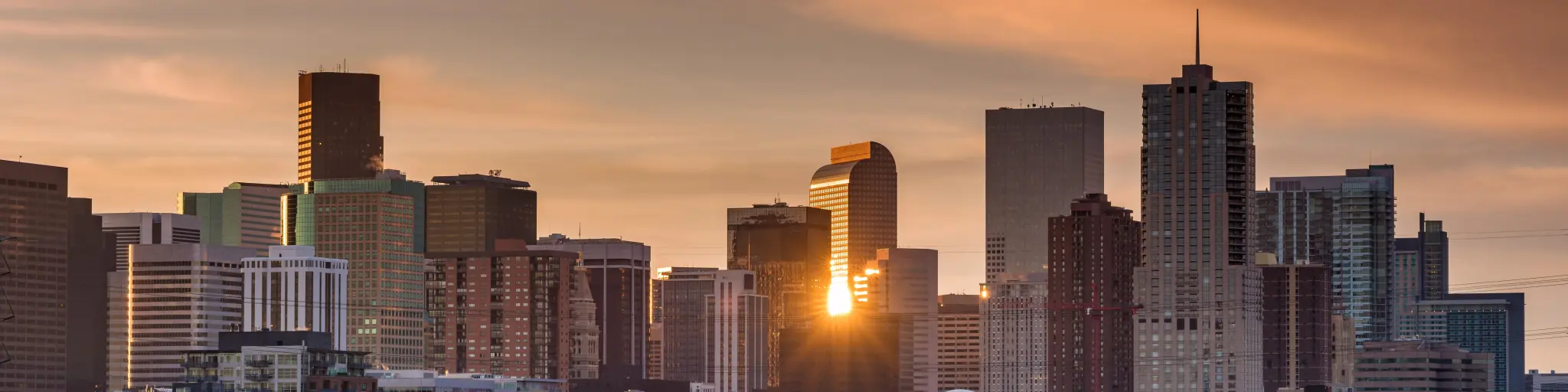 Denver skyline, sun setting behind the skyscrapers