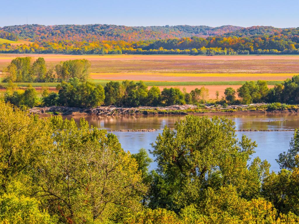 Missouri River banks, USA with a beautiful view of river in the the fall; fields on lower bank and woody bluffs in background on a sunny day.