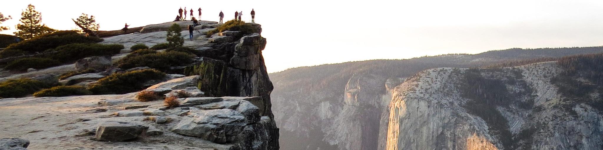 Distance view of hikers at the summit Taft Point at Yosemite National Park
